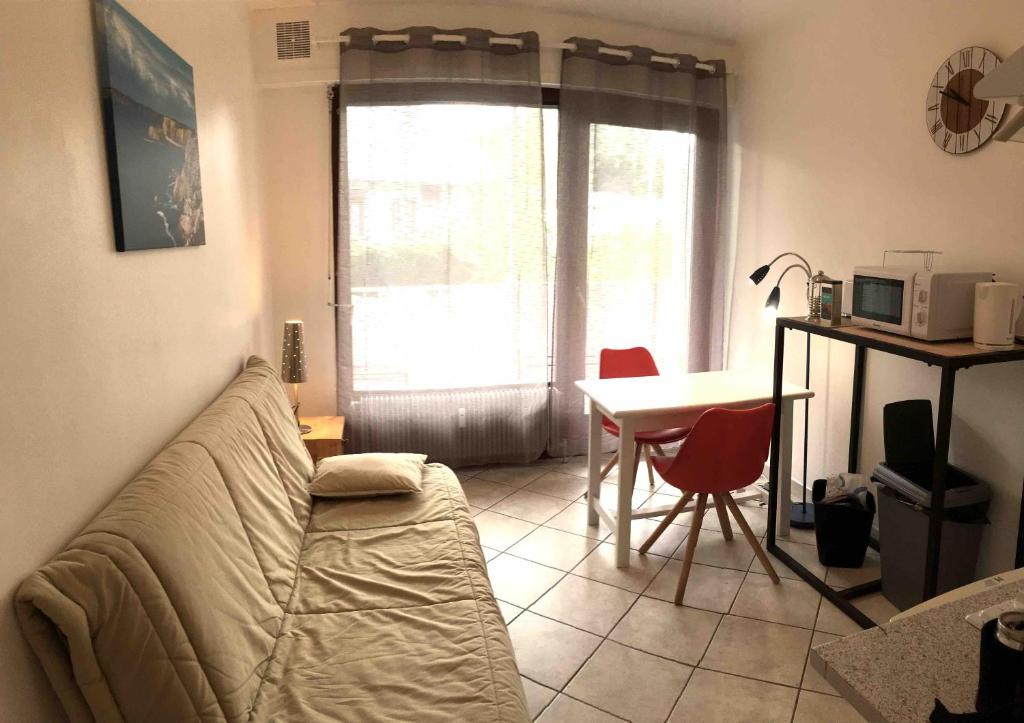 un soggiorno con divano, tavolo e finestra di Studio KLOSSTER a Chambéry
