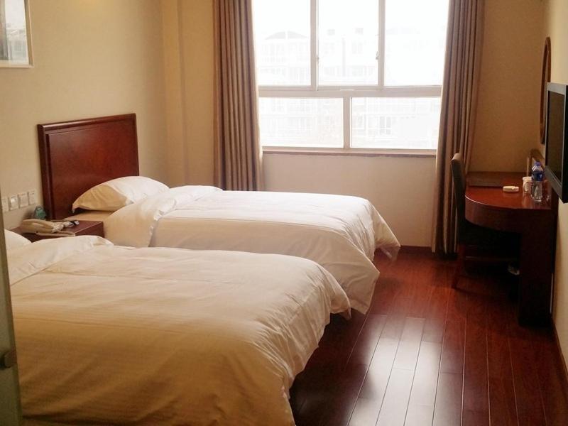 een hotelkamer met 2 bedden en een raam bij GreenTree Inn HeBei HanDan DaMing Tianxiong Road Yuancheng Road Express Hotel in Daming