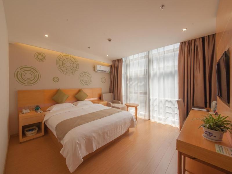 GreenTree Inn Jiangsu Suzhou Gongyequan District Xinglong Street Express Hotel tesisinde bir odada yatak veya yataklar