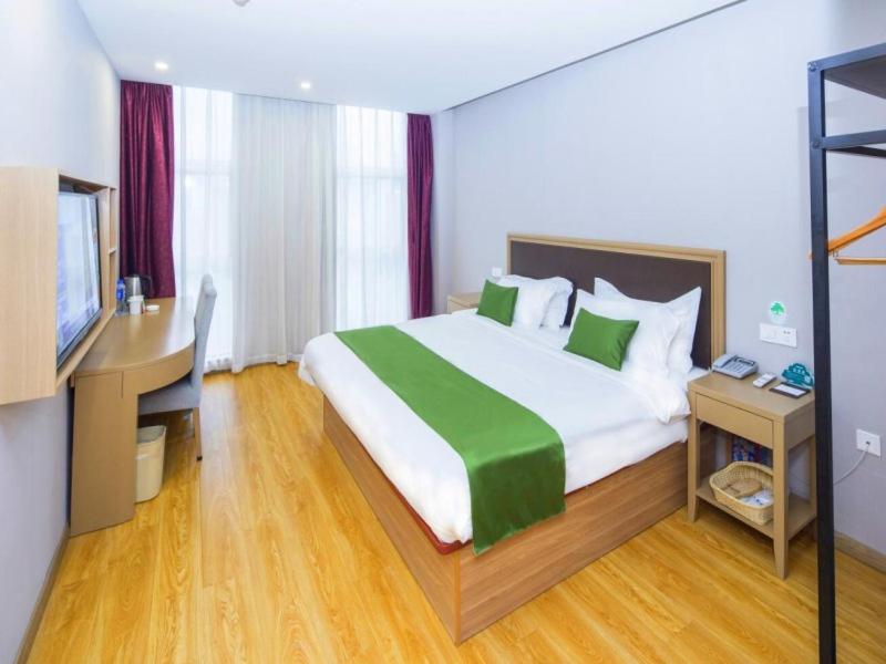 um quarto com uma cama grande, uma secretária e um computador em GreenTree Inn Tianjin Xiqing Development Zone Renrenle Square Express Hotel em Tianjin