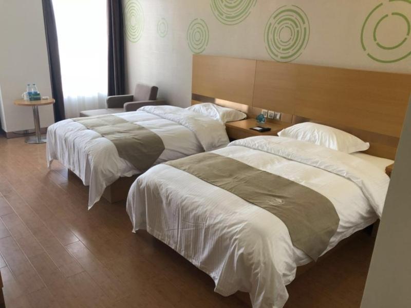 um quarto de hotel com duas camas e uma cadeira em GreenTree Inn Xi'an Gaoling District Handan Industrial Park Express Hotel em Xi'an
