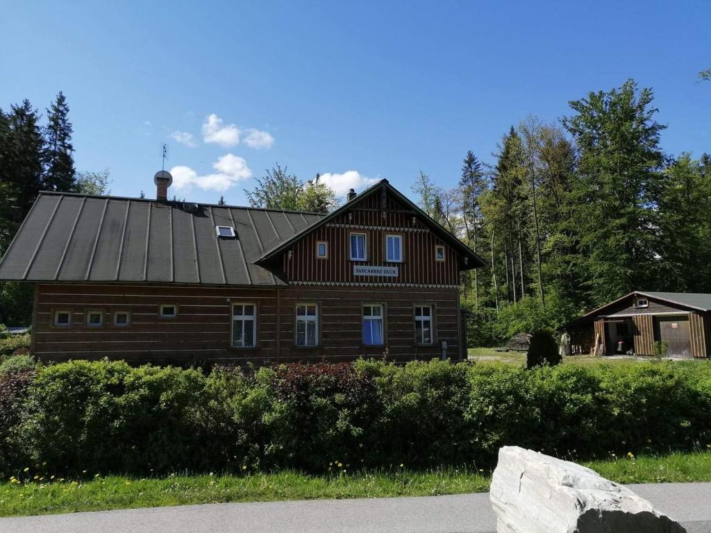 uma grande casa de madeira com um telhado de gambrel em chata Švýcarský dvůr em Janske Lazne