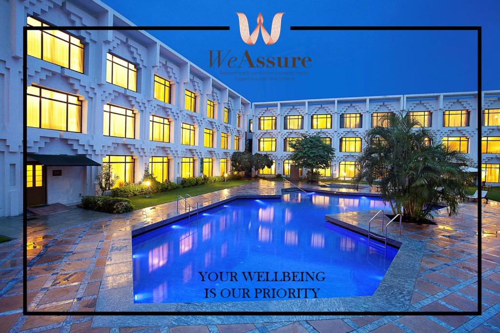 a building with a swimming pool in front of it at Welcomhotel by ITC Hotels, Alkapuri, Vadodara in Vadodara