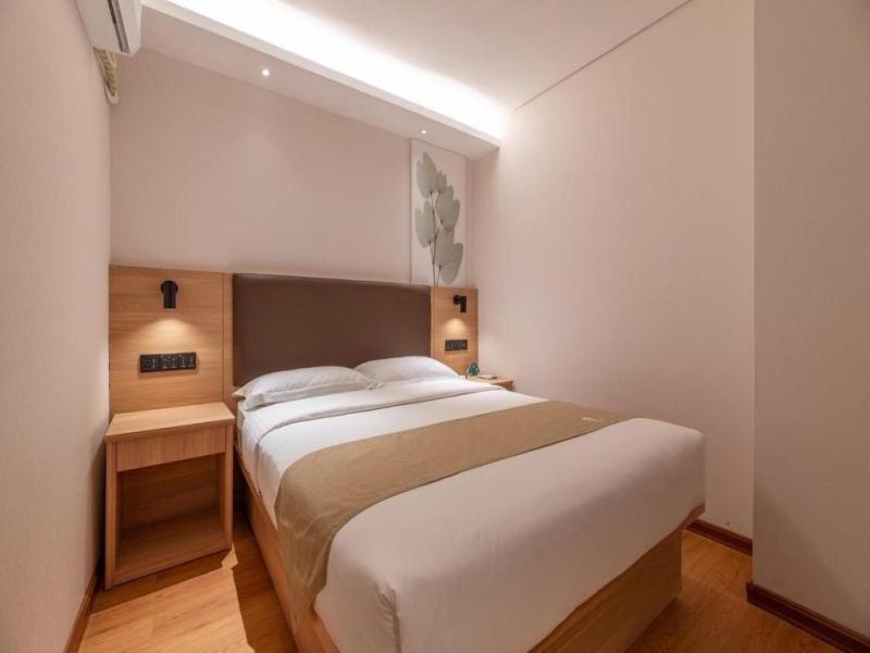 a bedroom with a large white bed in a room at GreenTree Inn Ji‘nan Shanda Road Business Hotel in Jinan