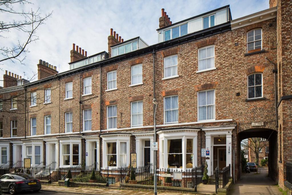 un gran edificio de ladrillo rojo con una puerta en Hedley House Hotel & Apartments, en York