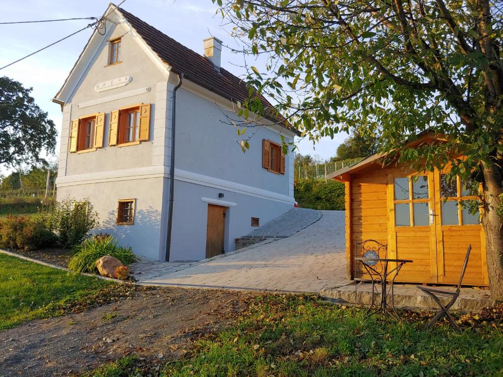 una pequeña casa blanca con un cobertizo amarillo en kleine Reblaus en Bad Waltersdorf