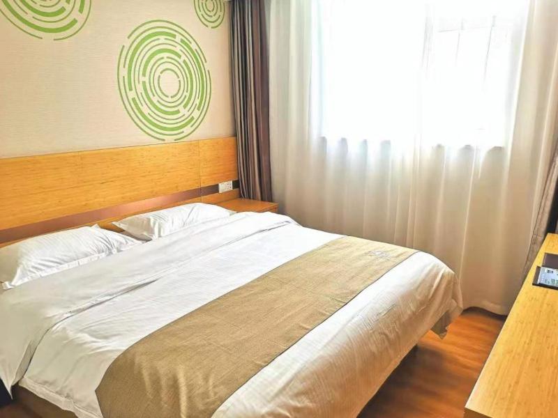 a bedroom with a white bed with a window at GreenTree Inn Beijing Chaoyang District Maquanying Subway Station Express Hotel in Beijing