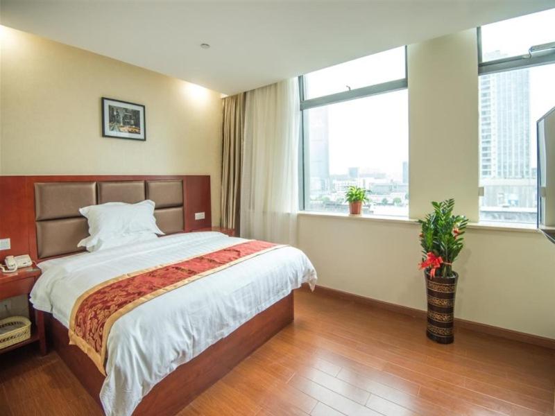 a bedroom with a large bed and two windows at GreenTree Inn JiangSu Suzhou Wuzhong District Dongwu North Road Business Hotel in Suzhou