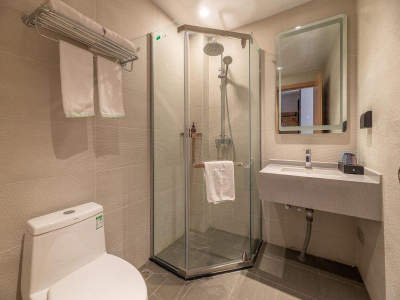 a bathroom with a shower and a toilet and a sink at GreenTree Inn Ji‘nan Shanda Road Business Hotel in Jinan