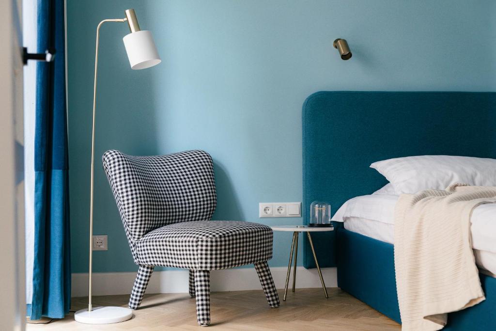 里加的住宿－MIRO Rooms - French chic, free private parking，一间卧室配有椅子和蓝色的墙壁