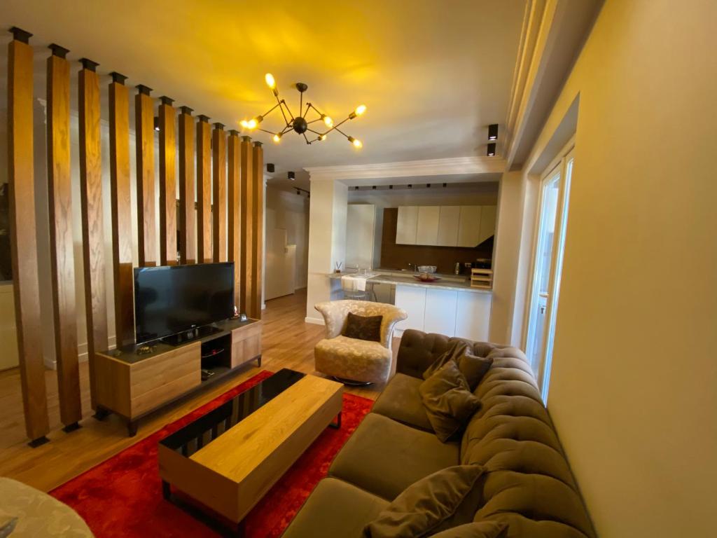 sala de estar con sofá y TV en Mel’s Place, en Tirana
