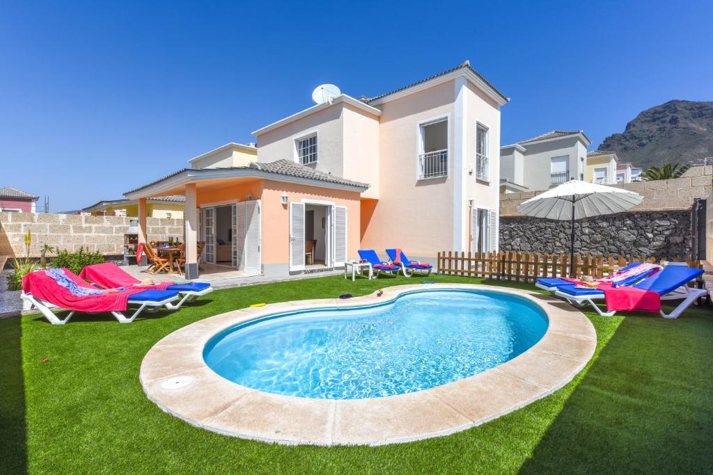 ein Haus mit Pool im Hof in der Unterkunft Villa Aloe con piscina climatizada, Playa Fañabe, Costa Adeje in Adeje