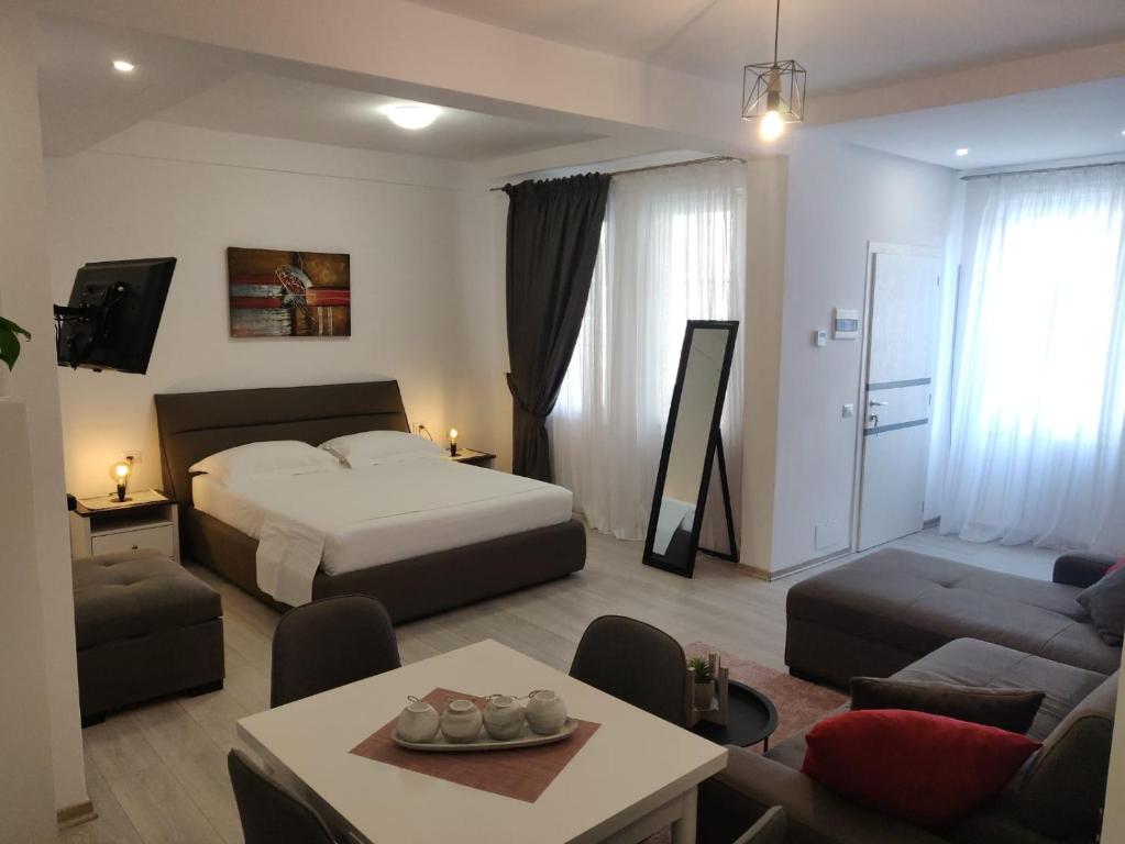 a bedroom with a bed and a living room at E&A Apartments Guesthouse in Durrës