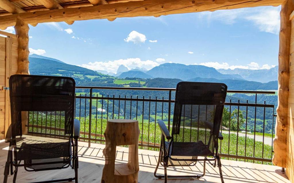 two chairs on a porch with a view of the mountains at Schweiggerhof -Agriturismo- Farm Holidays in Villandro