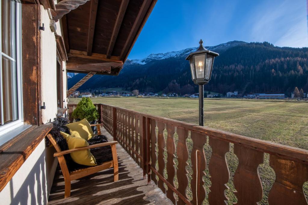 a porch with a lamp and a view of a field at Florin Ferien in Klosters