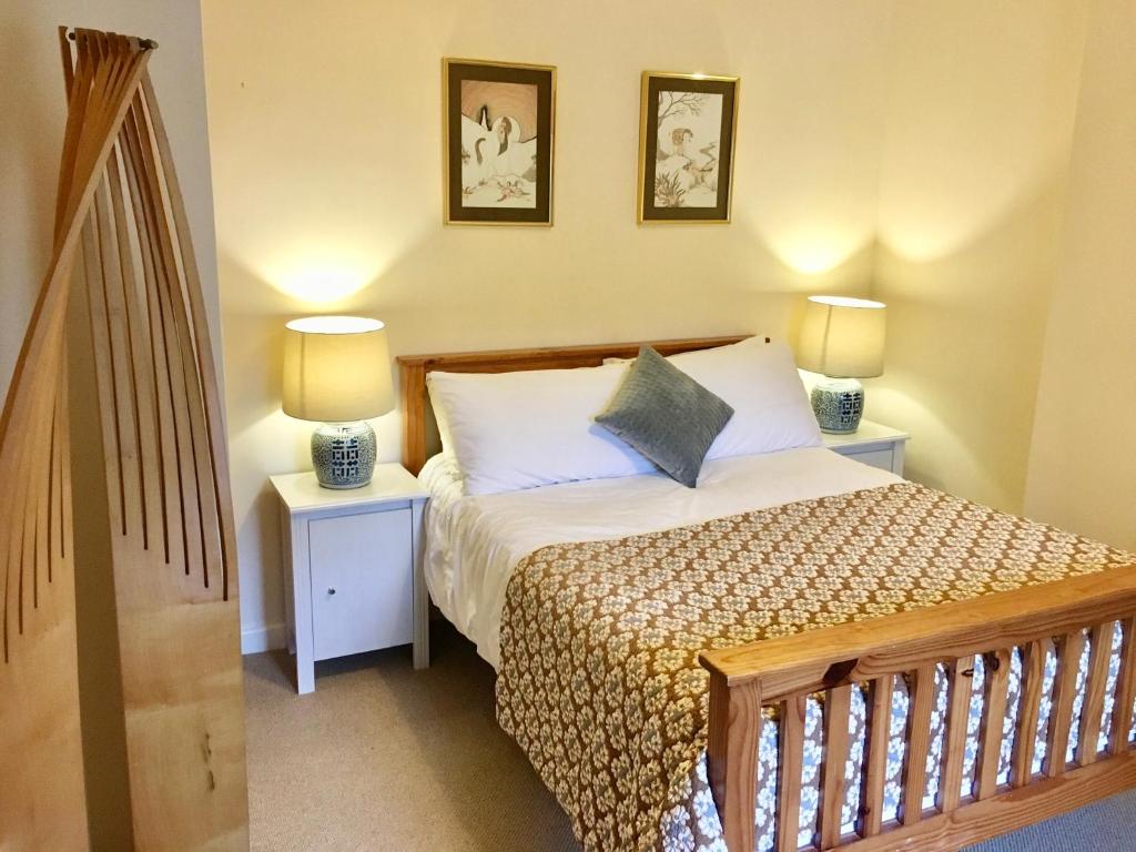 Climbers Cottage في Rosedale Abbey: غرفة نوم صغيرة بها سرير ومداخلة ليلتين