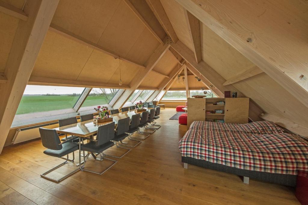 een kamer met een eettafel en stoelen op een zolder bij Gastopstal in Wyns