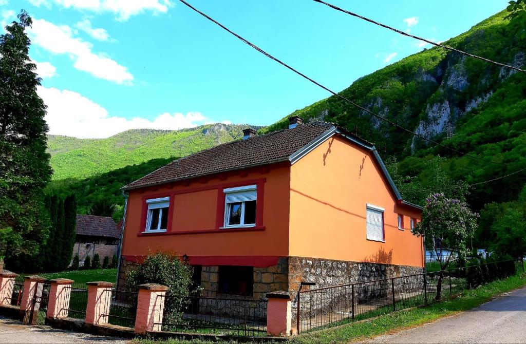 ein kleines Haus vor einem Berg in der Unterkunft NAXI GUEST HOUSE in Perućac