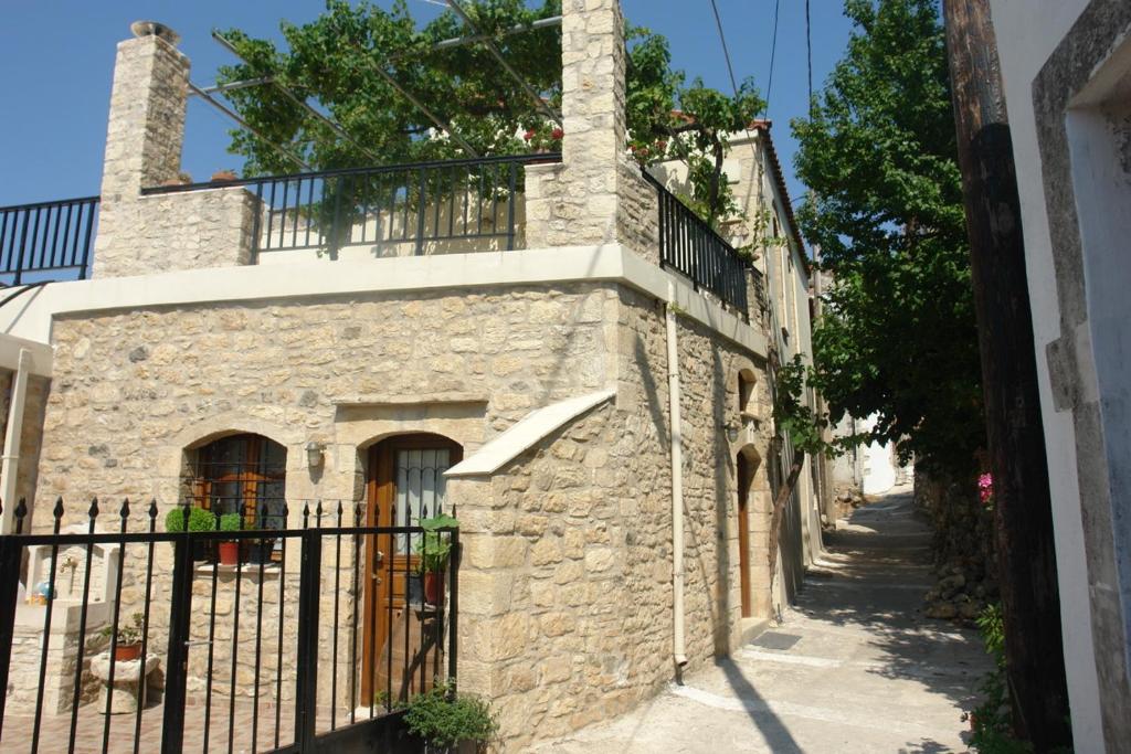 een oud stenen huis met een zwart hek bij Villa Eleva in Argyroupolis
