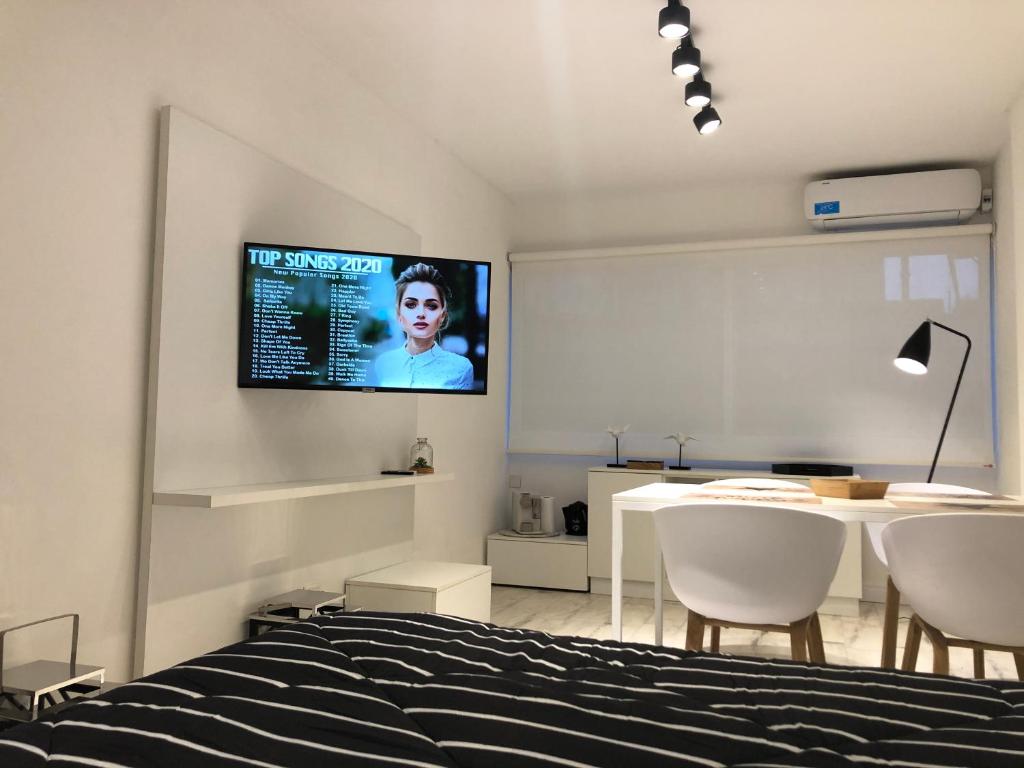 1 dormitorio con 1 cama y TV en la pared en Emerald Apart Microcentro en Buenos Aires