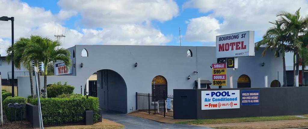 ein weißes Gebäude mit einem Motelschild davor in der Unterkunft Bourbong St Motel in Bundaberg