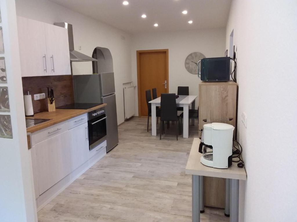 a kitchen with white cabinets and a table with a appliance at Amera-Ferienwohnung in Lübeck