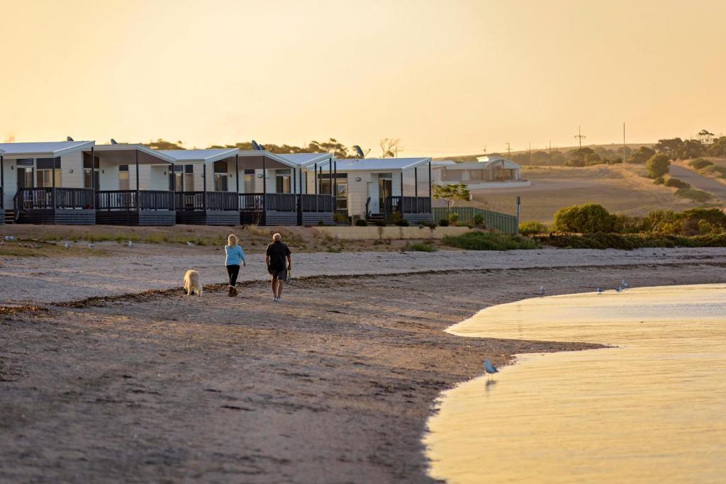 two people walking on a beach near a body of water at Discovery Parks - Streaky Bay Foreshore in Streaky Bay