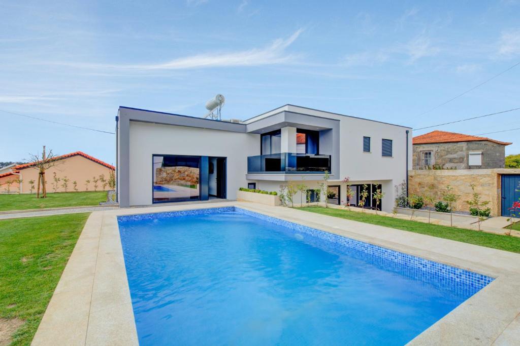 a house with a swimming pool in front of a house at 3 bedrooms villa with private pool enclosed garden and wifi at Esposende in Esposende