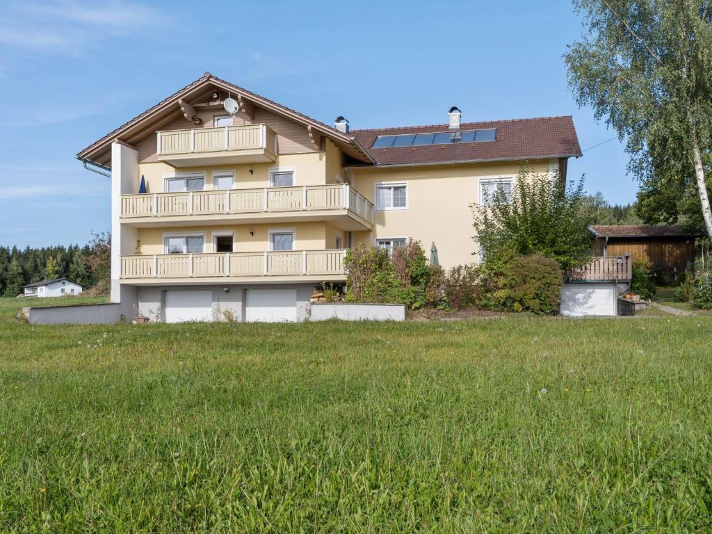 een huis op een heuvel met een groen veld bij Spacious apartment in the Bavarian Forest in Viechtach