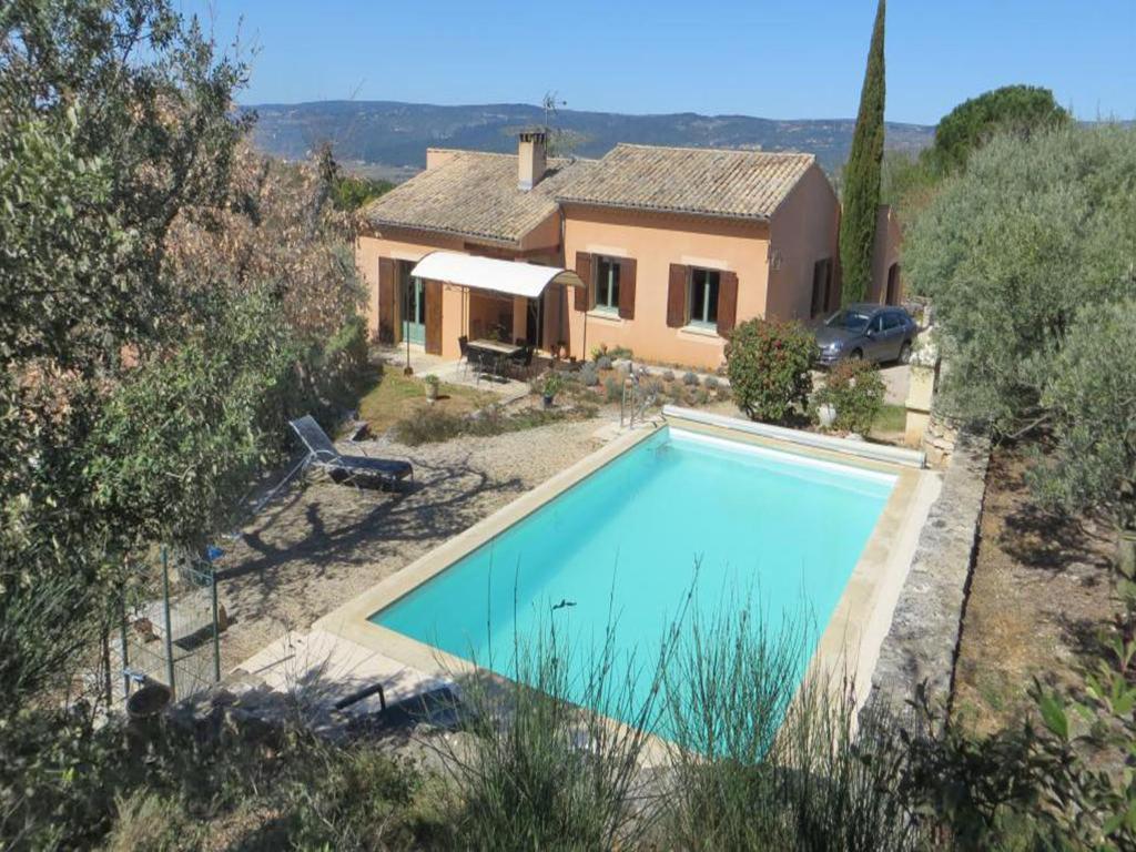 uma grande piscina em frente a uma casa em Detached holiday home with private pool in the village of Roussillon em Murs