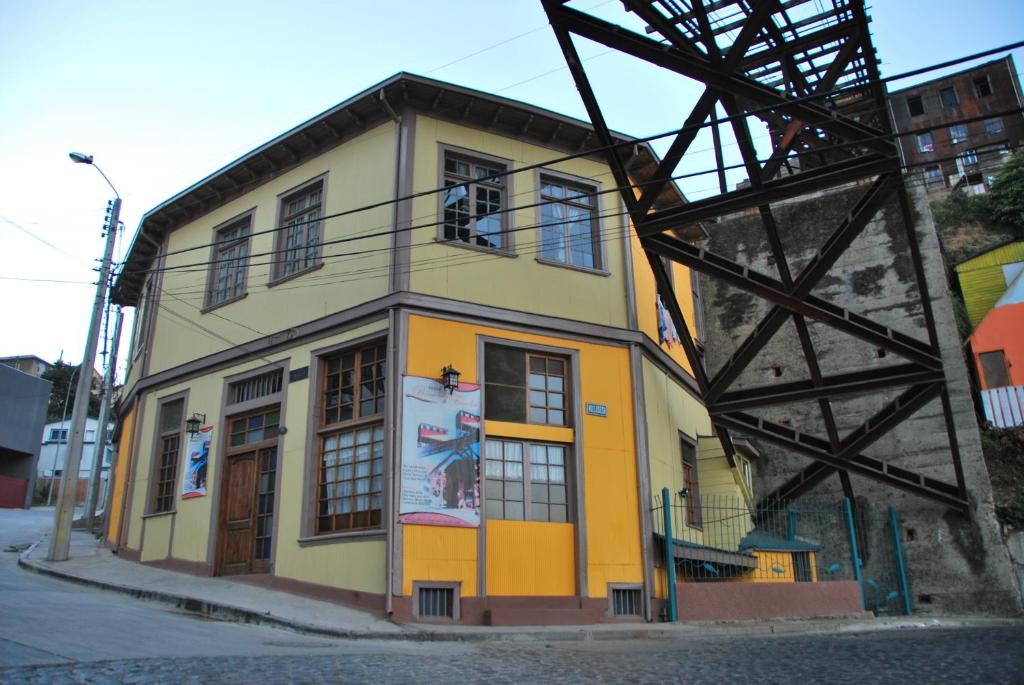 een geel en oranje gebouw naast een metalen toren bij Hostal Recuerdos de Familia in Valparaíso