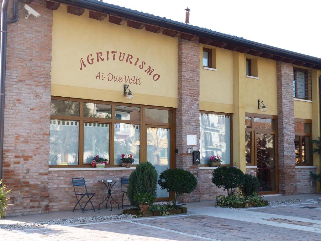 uma loja com uma placa na lateral de um edifício em Agriturismo Ai Due Volti em Dossobuono