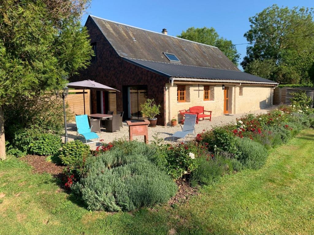 a house with a patio and chairs in the yard at Detached holiday home in the Normandy countryside in Saint-Germain-du-Pert