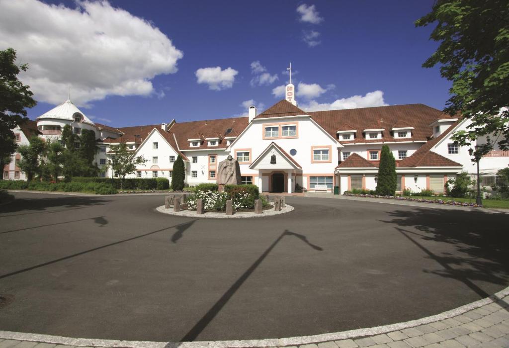 duży biały budynek z ulicą przed nim w obiekcie Quality Hotel Olavsgaard w mieście Skjetten