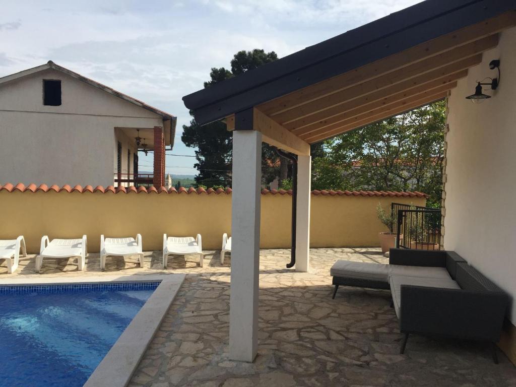 a patio with a swimming pool next to a house at Lovely Villa in Ka telir Croatia with Private Pool in Labinci