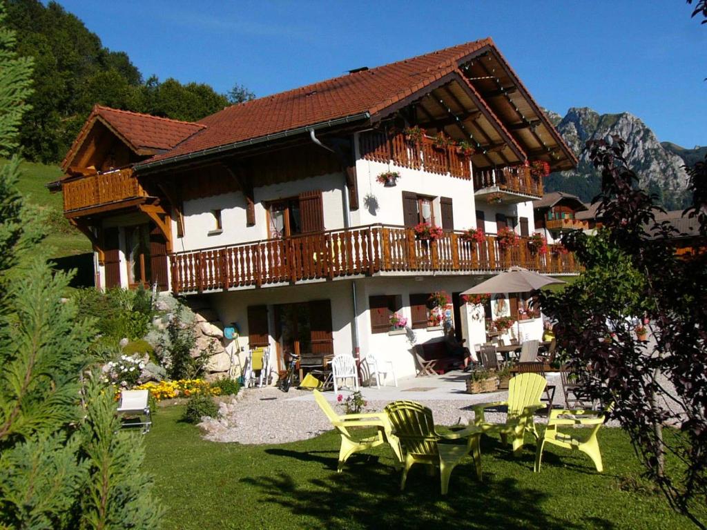 a large house with a balcony and a table and chairs at Chalet Gîte Le Titlis in Bernex