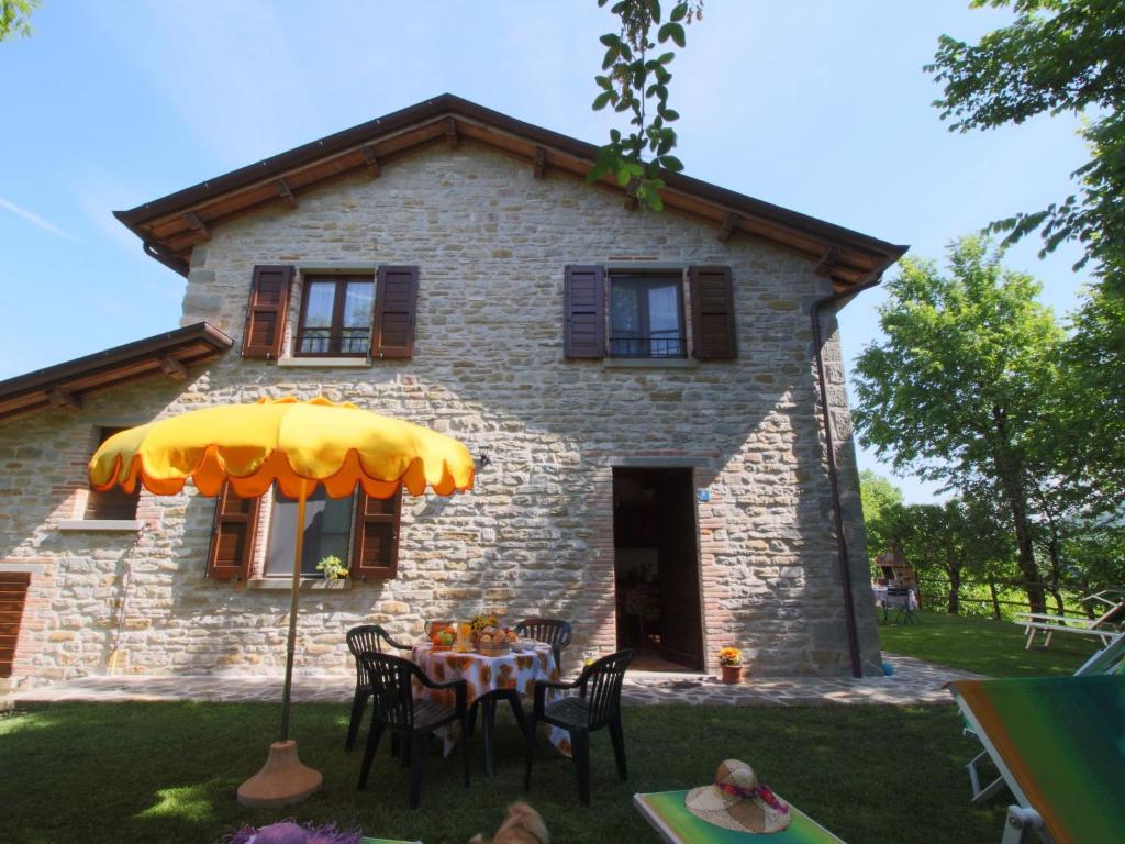 a stone house with a table in front of it at Belvilla by OYO Il Girasole in Apecchio