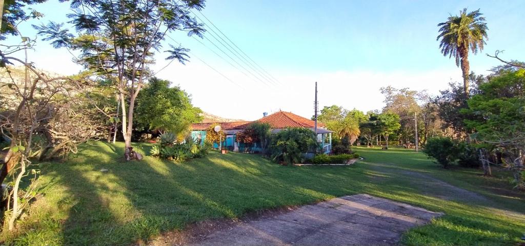 un patio con una casa y un campo de césped en Camping São Pedro - Diamantina, en Diamantina