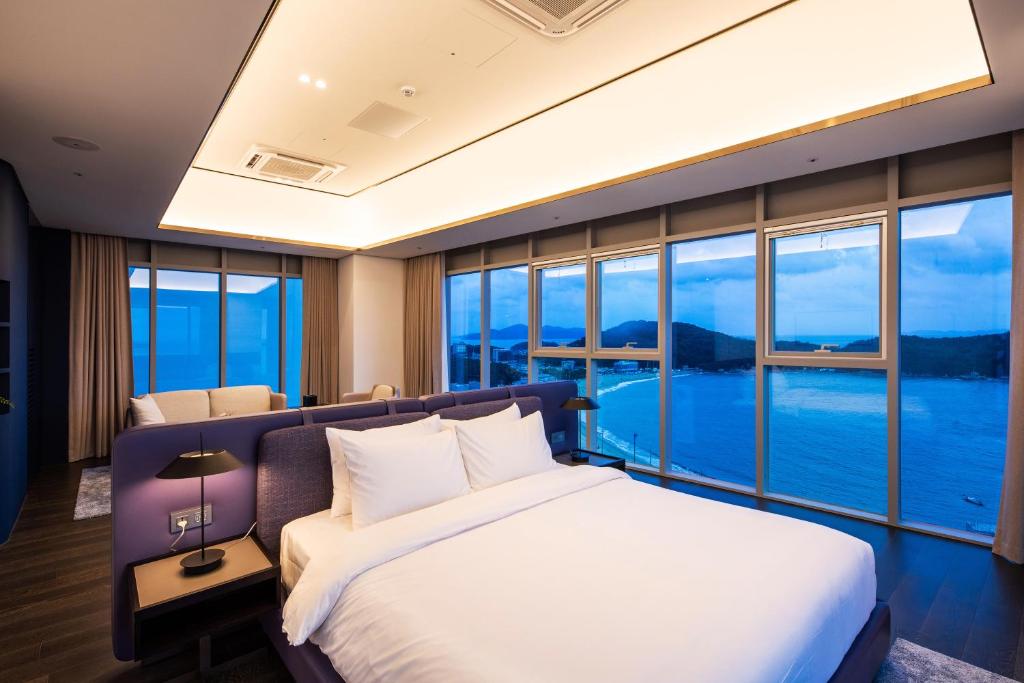 a bedroom with a large bed and large windows at The Week & Resort in Incheon