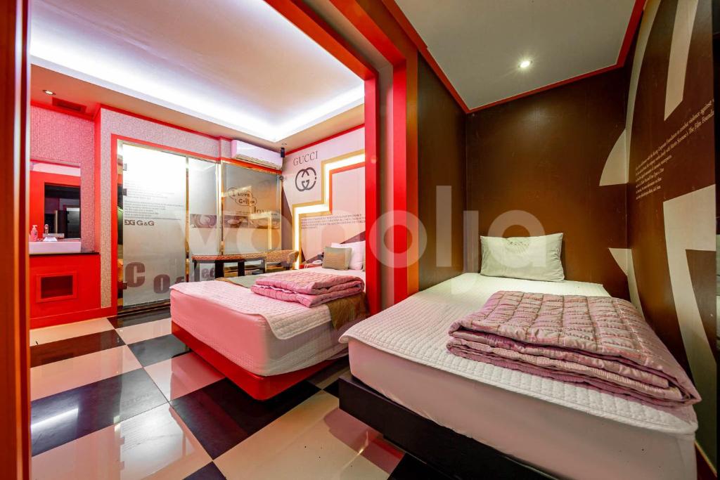 晉州的住宿－GnG晉州汽車旅館，一间设有两张床和一台电视的房间
