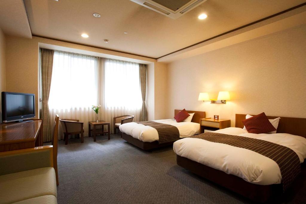 Postel nebo postele na pokoji v ubytování Dogo Prince Hotel