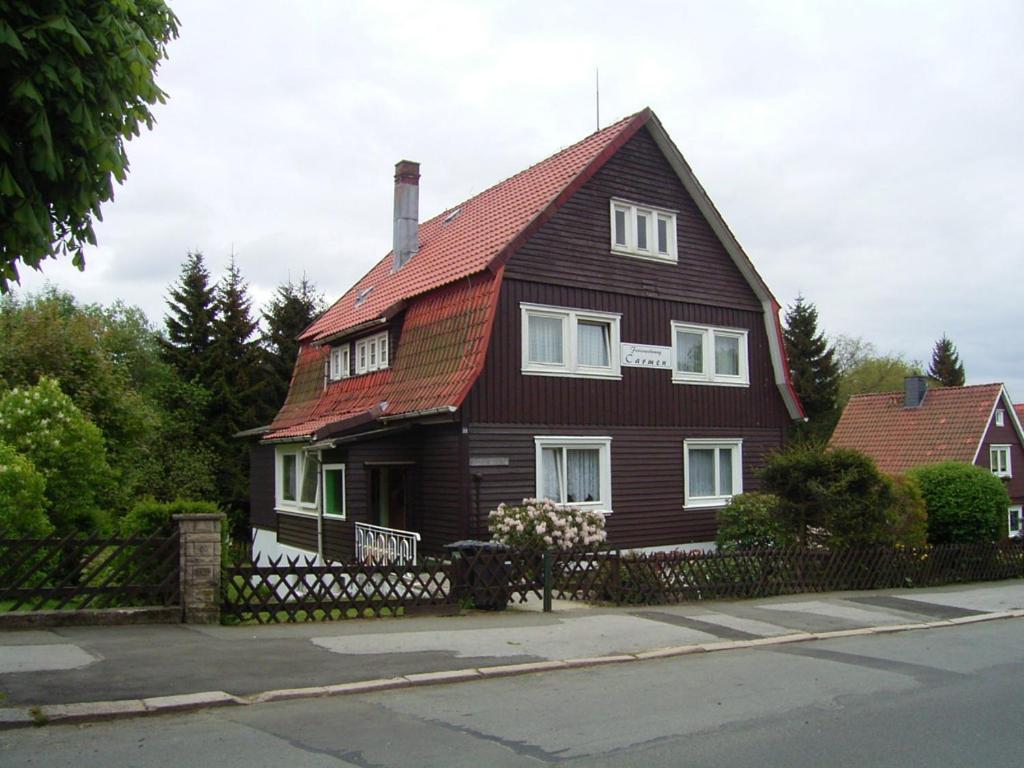 una casa marrón con techo rojo en Apartments Carmen, en Braunlage