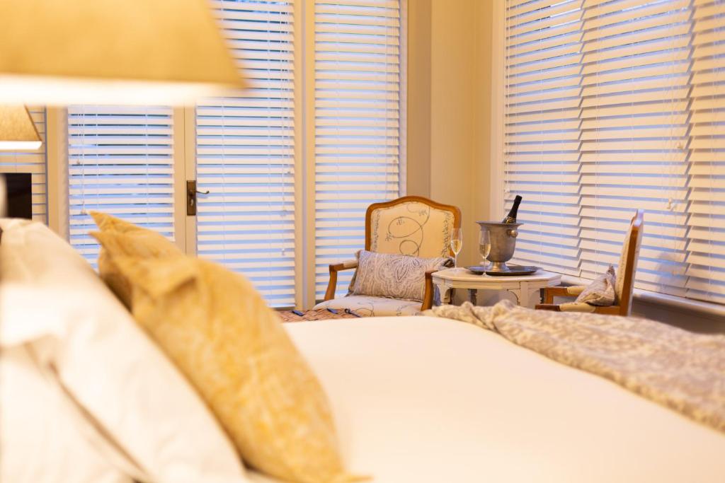 a bedroom with a bed and a chair and windows at The Rivulet in Hobart