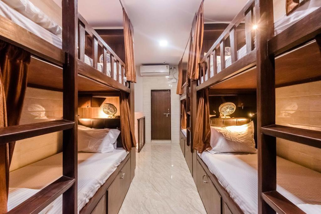 a hallway with four bunk beds in a room at Awesome Dormitory Male Only in Mumbai
