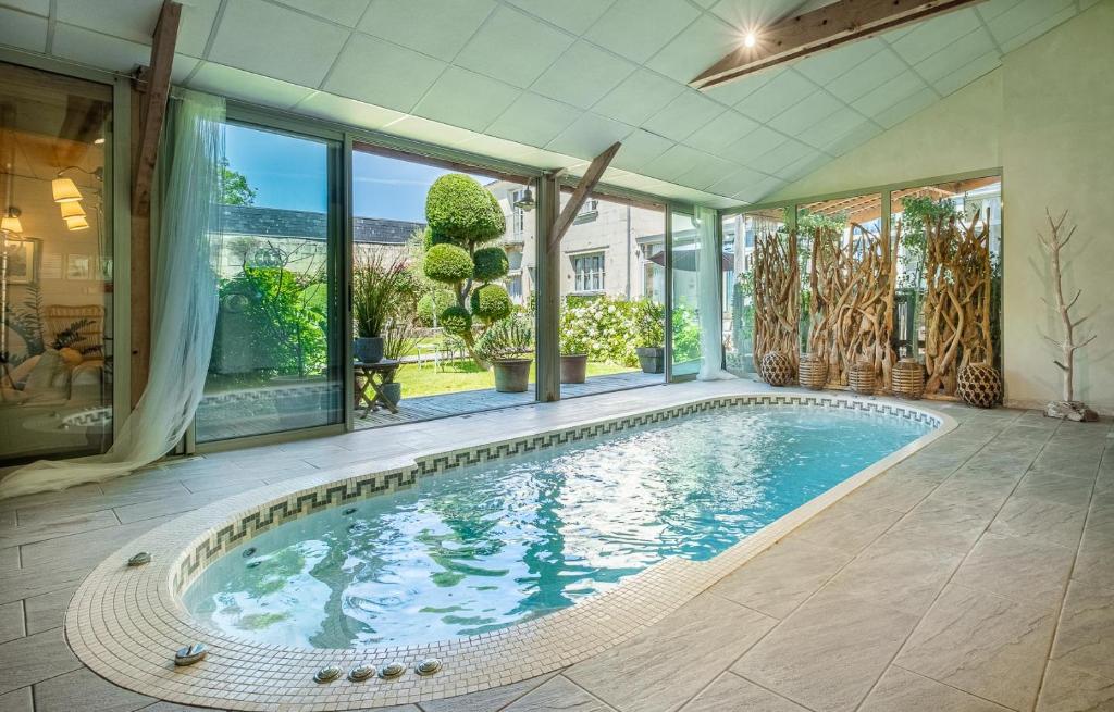 an indoor swimming pool in a house with windows at Appartements & Spa de la Marine Loire in Montsoreau