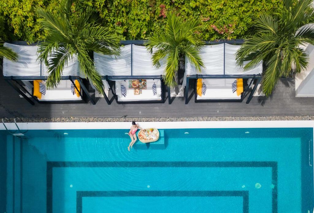 einen Ausblick auf eine Person in einem Surfbrett in einem Pool in der Unterkunft Hoian Sincerity Hotel & Spa in Hoi An