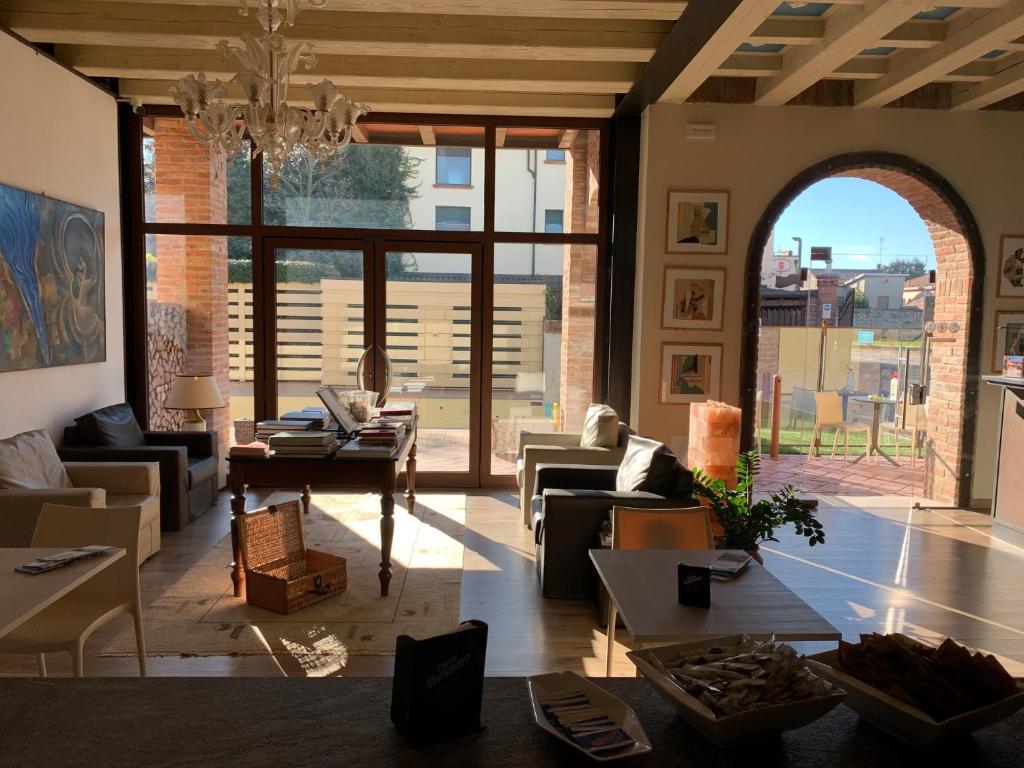 a living room filled with furniture and a large window at Luna Residence Hotel in Casalmaggiore