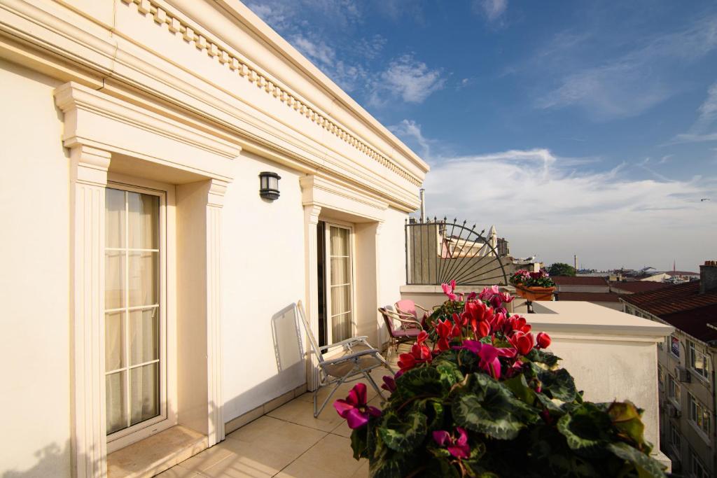 a balcony with pink flowers on a white building at Recital Hotel in Istanbul