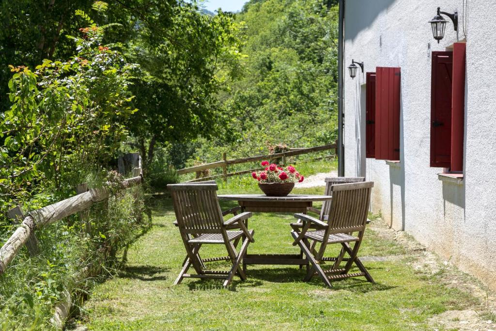 dwa krzesła i stół z wazonem kwiatów na nim w obiekcie Casa Rural Toki Ona II w mieście Valcarlos