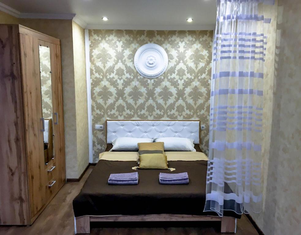 a bedroom with a bed with two towels on it at Soborna 31 in Kamianets-Podilskyi